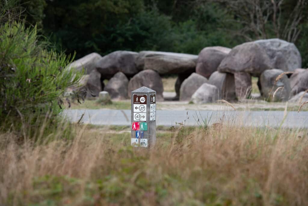 Knooppuntpaal met op de achtergrond een hunebed